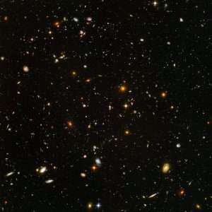 Hubble Deep Field picture showing tens of thousands of glowing galaxies